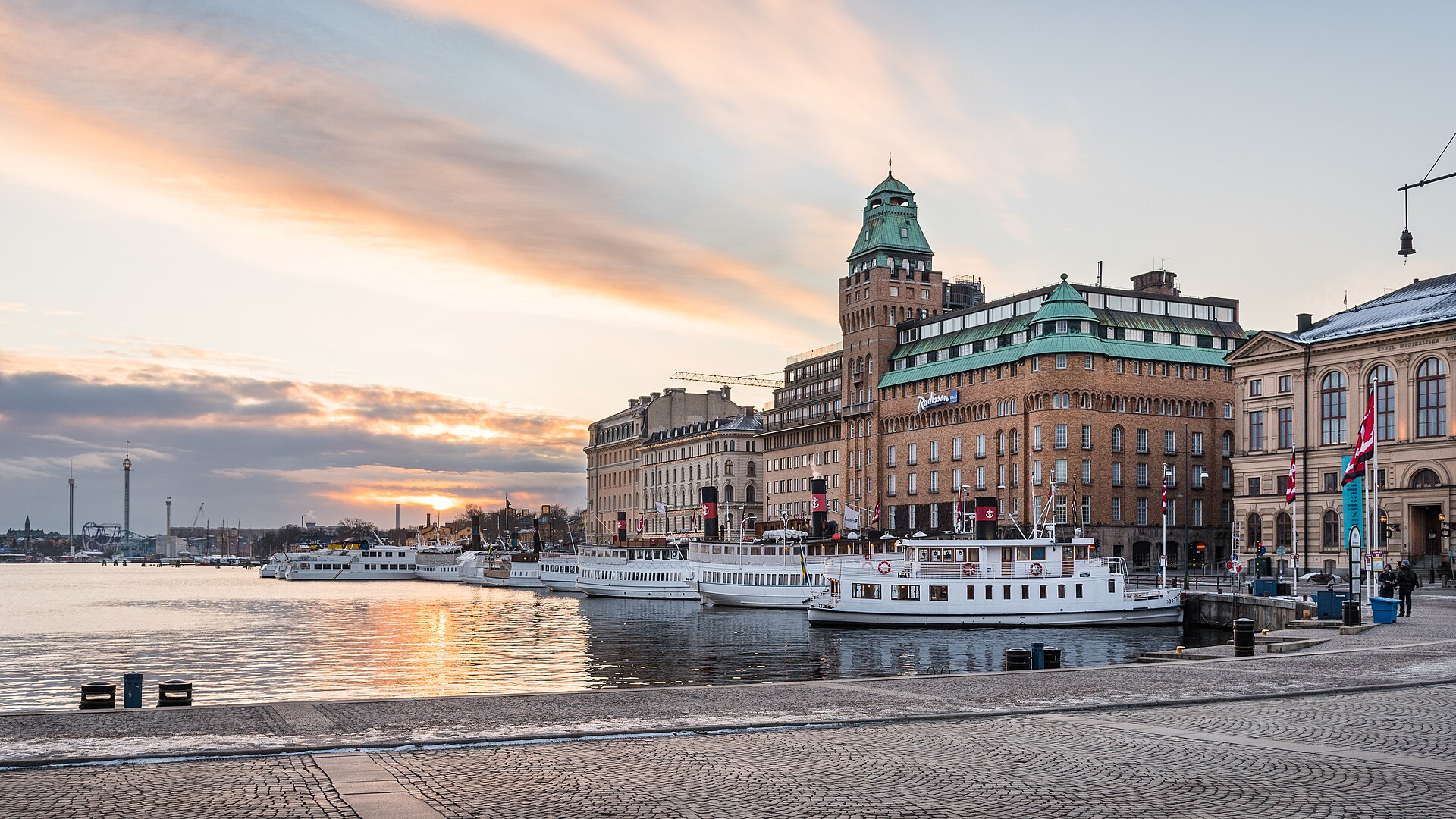 Nybrokajen and Blasieholmen in Stockholm, with the Strand Hotel tower and archipelago boats along the quay