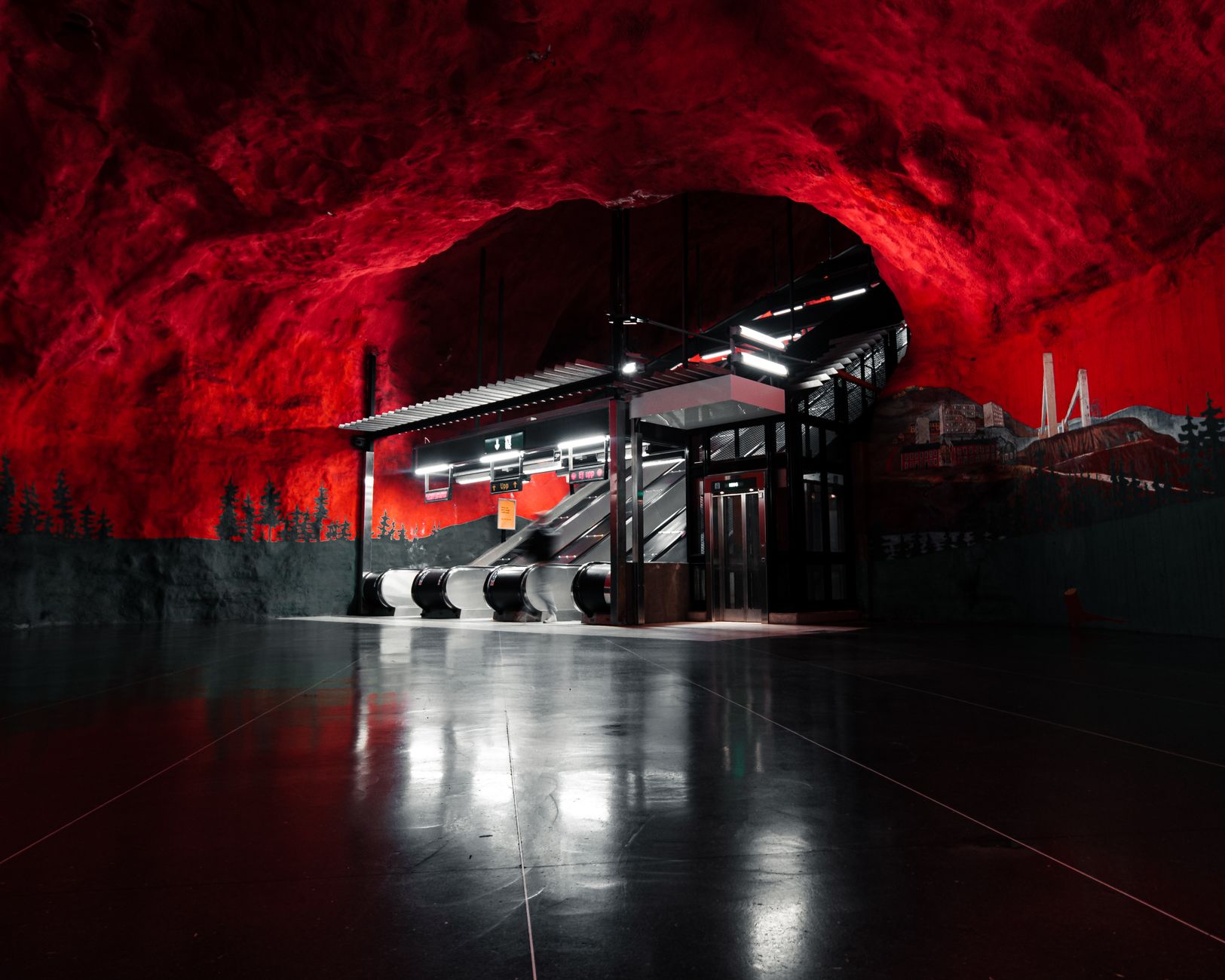 Vibrant red cave-like interior of a Stockholm metro station with escalators.