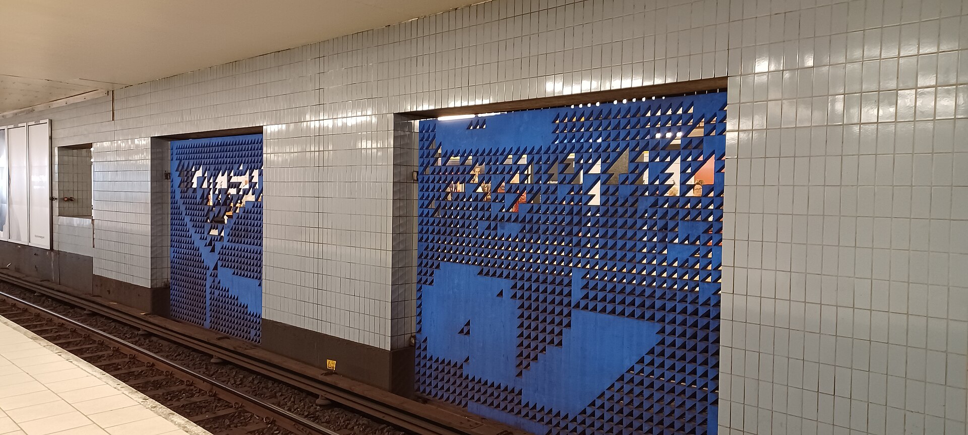 Perforated painted metal artwork on the northbound red line platform at Slussen metro station in Stockholm