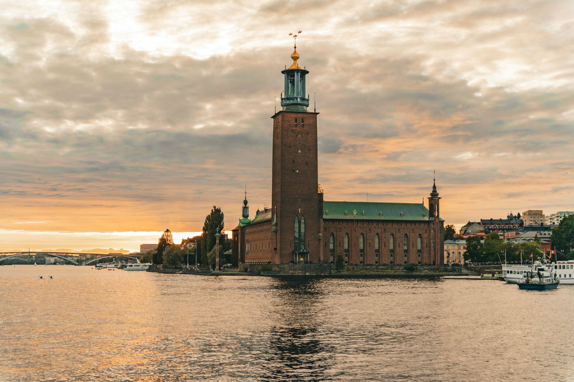 View of the iconic Stockholm City Hall during sunset, reflecting over the water in Stockholms län, Sweden
