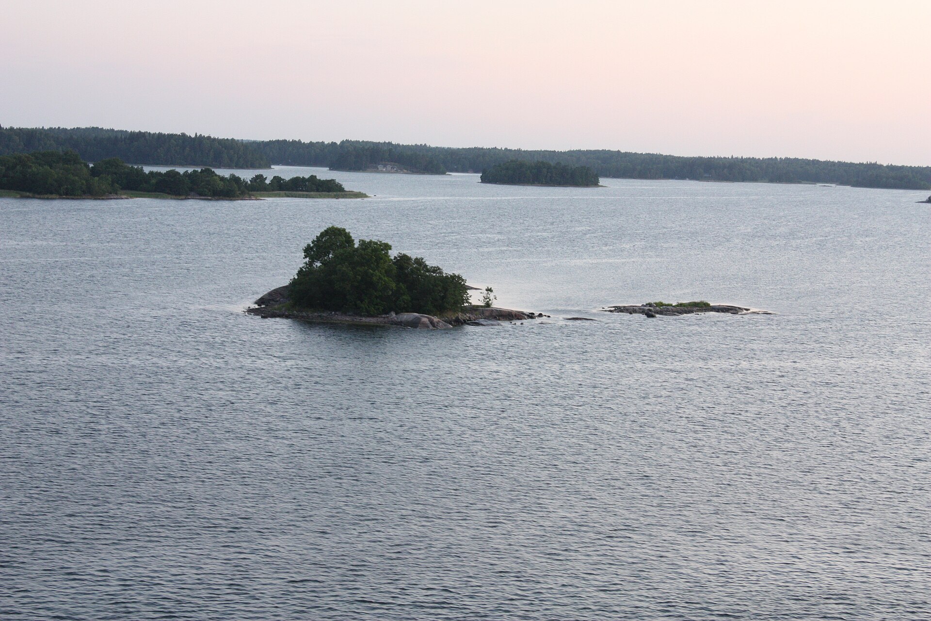 Waterside houses and rocks in the Stockholm archipelago seen from a ship