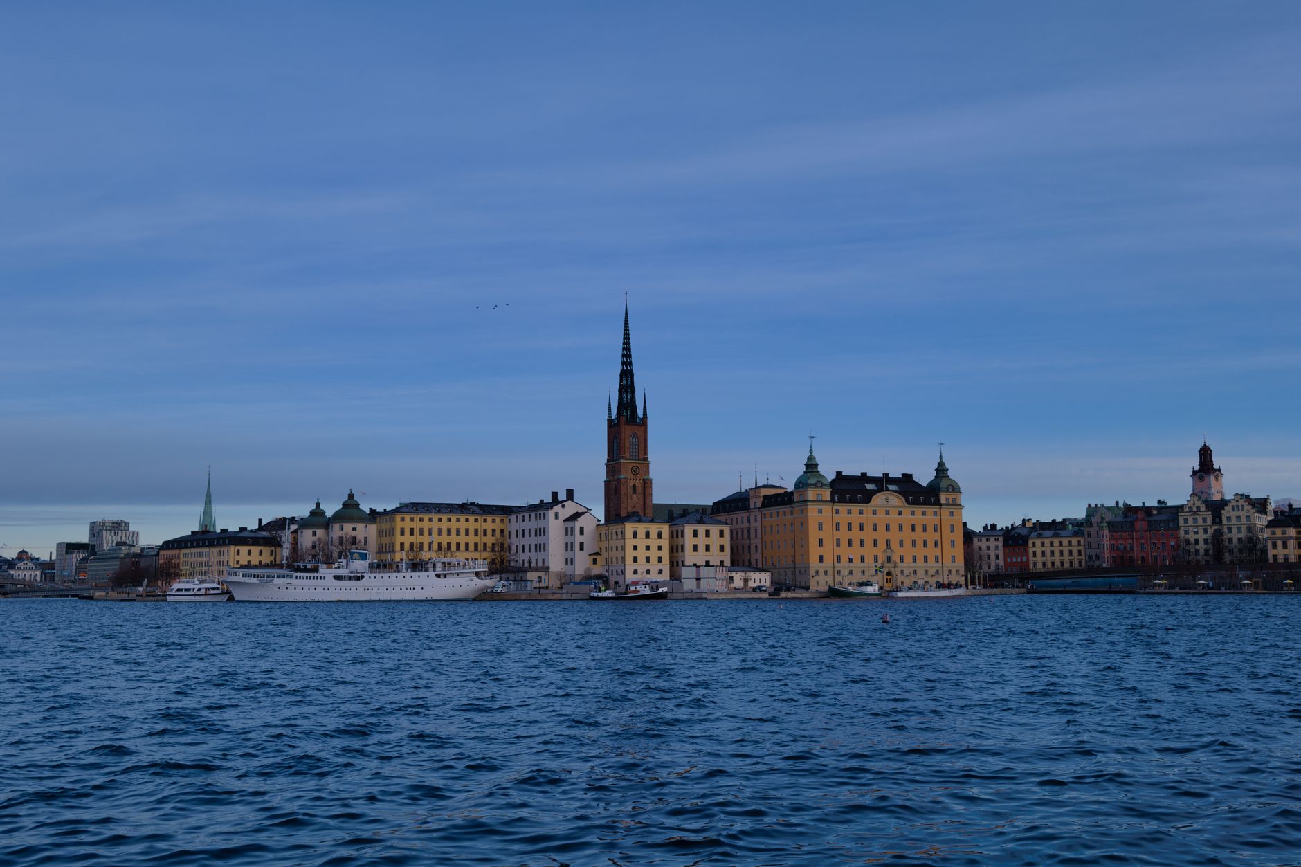 Skyline of Stockholm with historic architecture reflecting on water under a clear sky
