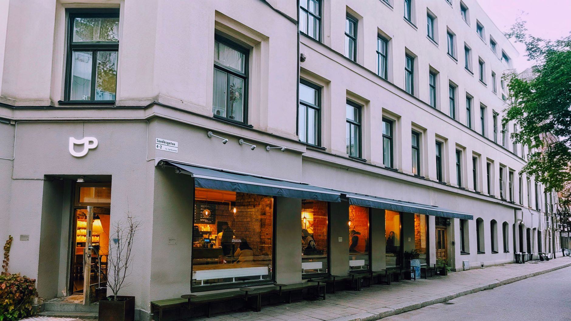 A cozy corner café in Stockholm with large windows illuminating the street. — illustrating What Is Systembolaget, and Why Does It Exist?