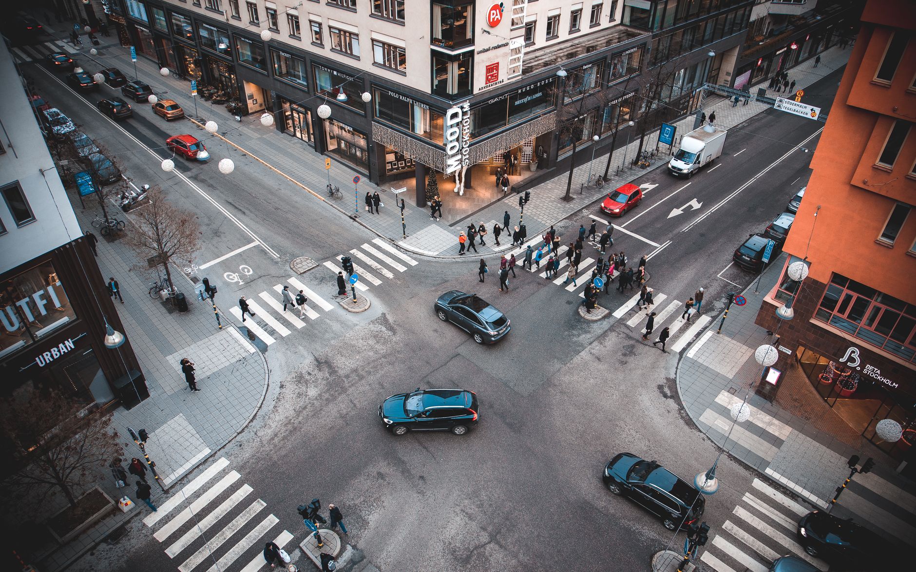 A bustling Stockholm street intersection with pedestrians and vehicles on a sunny day. — illustrating Which Public Holidays Close Things in Stockholm?
