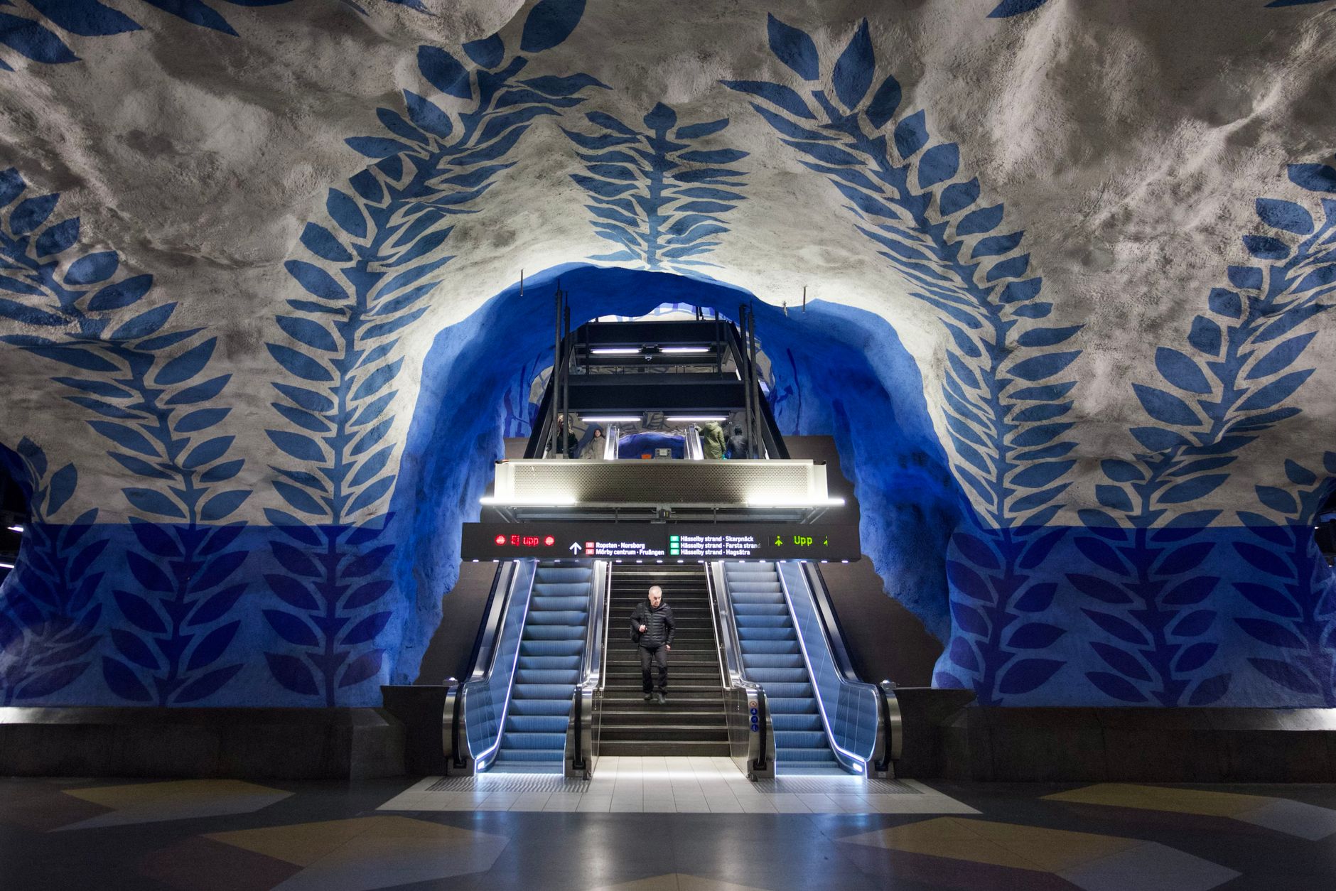 Vivid blue leaf patterns decorate the walls of Stockholm's T-Centralen metro station. — illustrating Why Is the Stockholm Metro Called the World’s Longest Art Gallery?